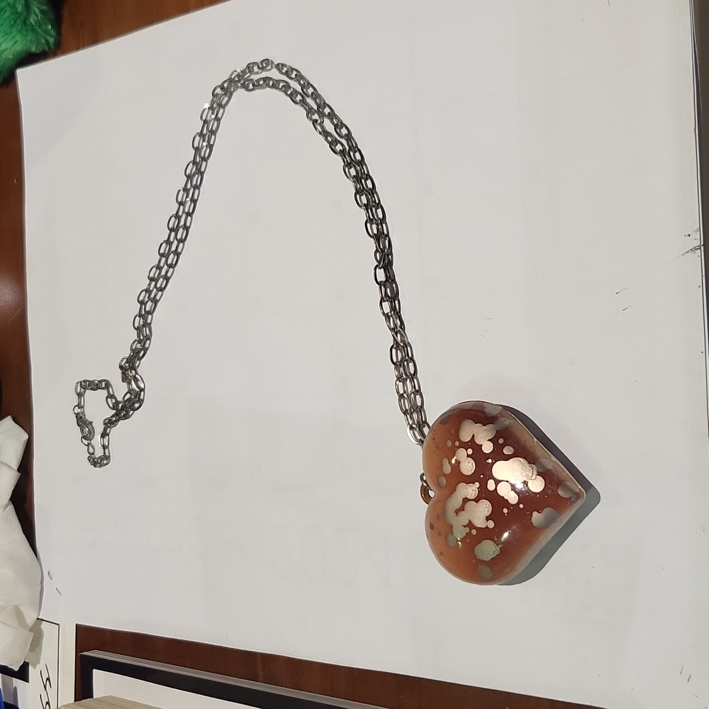 Costume jewelry necklace. Long silver chain with big chunky plastic heart